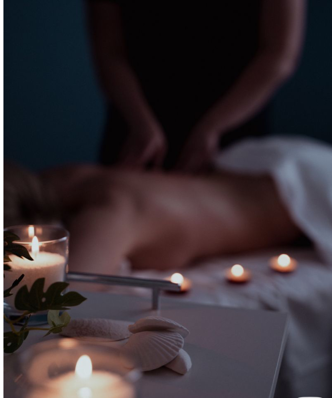 Masaje relajante en espalda con velas encendidas en la cabina