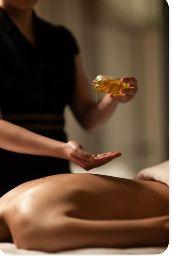 Terapeuta vertiendo aceite templado antes de un masaje tailandés